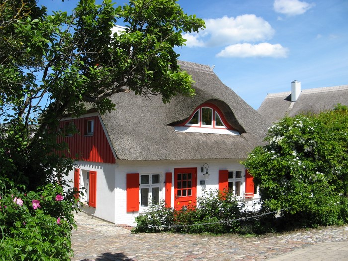 Thatched roof house with red shutters in Wustrow, Germany