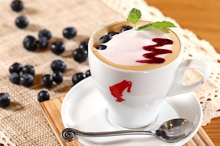 Blueberry latte with mint and syrup in a white cup