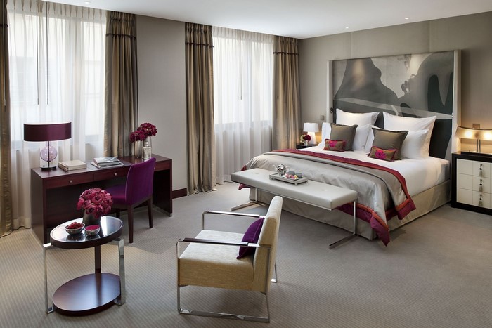 Luxury hotel bedroom with desk and seating area