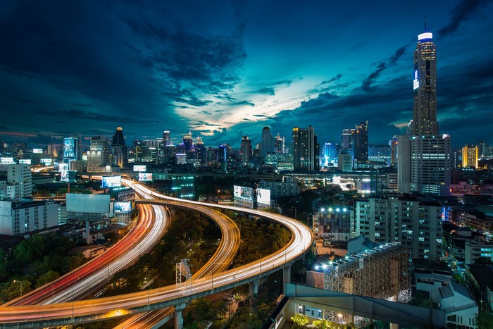 Nighttime cityscape with highway traffic and skyscrapers