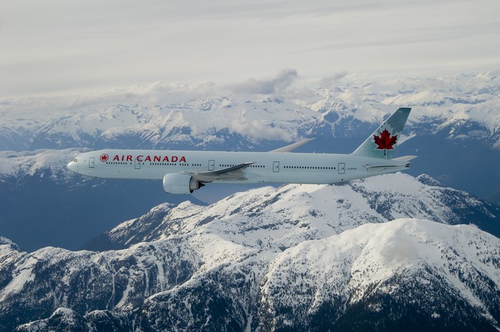 Air Canada Boeing 777-300ER flying over snow-covered mountains