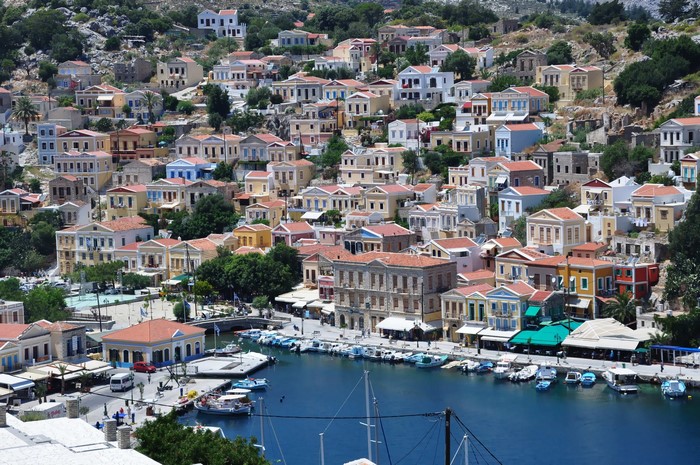 Colorful houses on a hillside overlooking a harbor in Greece