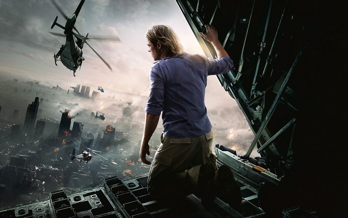 Man on top of a structure overlooking a destroyed city with helicopters