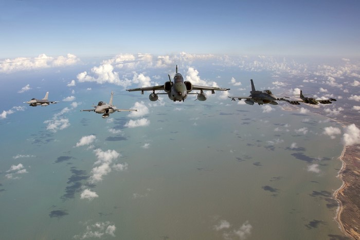 Fighter jets flying in formation over the ocean