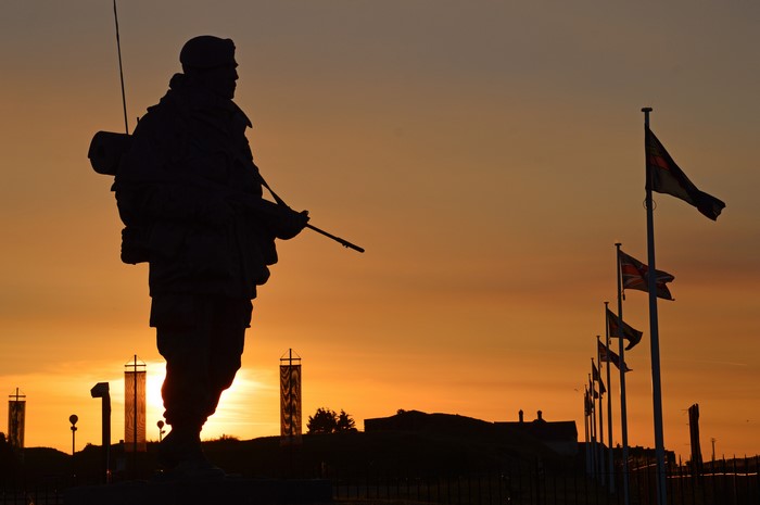 Soldier statue at sunset with flags