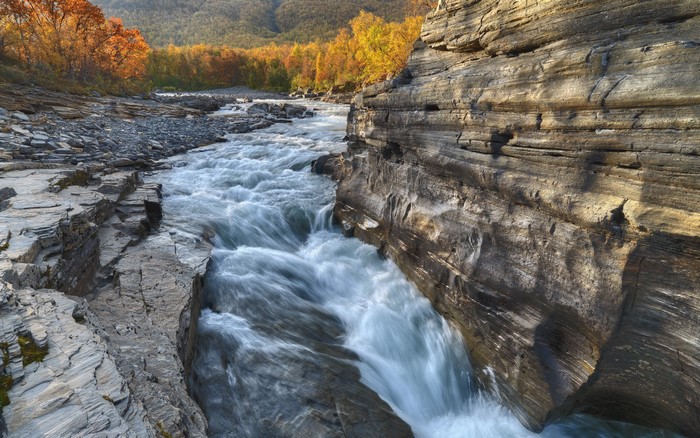 River flowing through rocky gorge in Abisko, Sweden during autumn