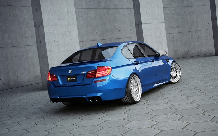 Blue BMW M5 F10 from behind on pavement
