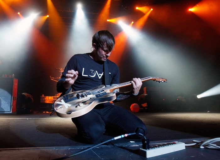 Tom DeLonge from Blink 182 playing guitar on stage