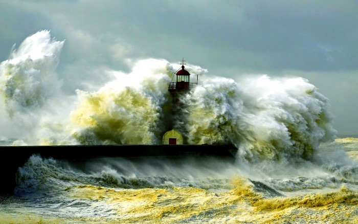 Lighthouse battered by massive waves during a storm
