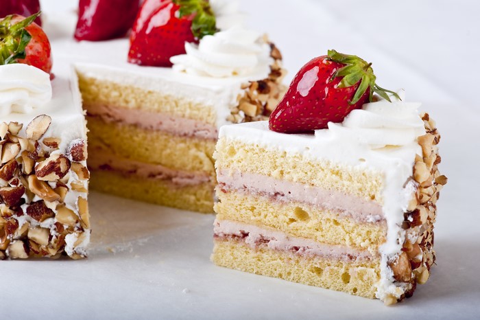 Strawberry cake slices with almonds and whipped cream