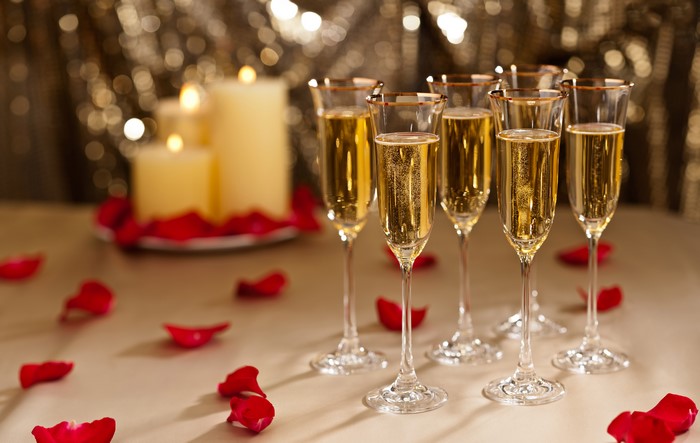 Champagne glasses with candles and rose petals