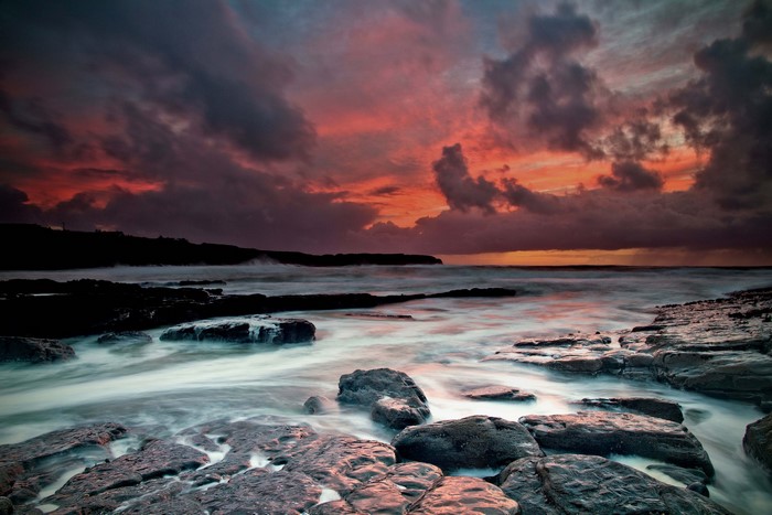 Dramatic sunset over rocky coast and sea in Ireland