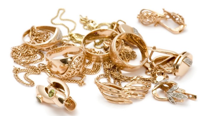 Gold rings and earrings with chains on white background