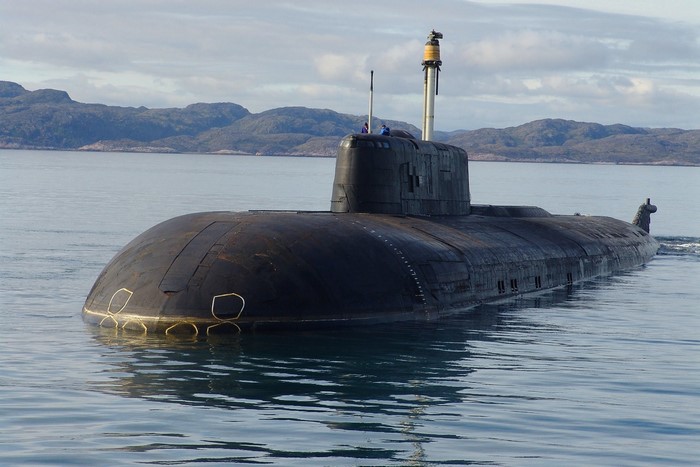 Submarine on the water with mountains in the background