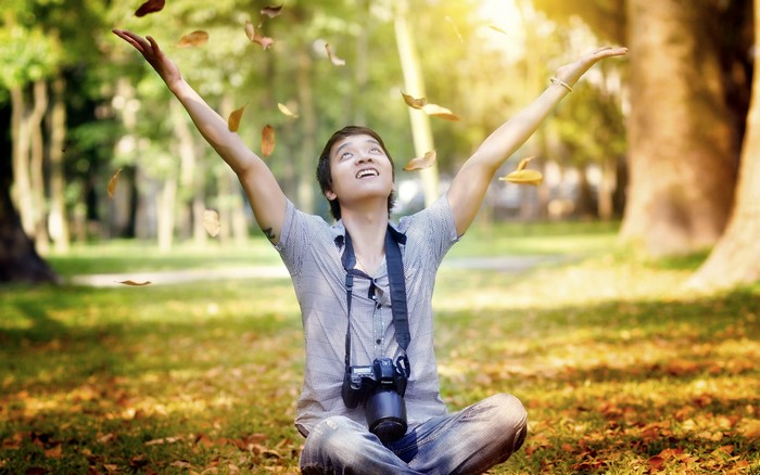 Young man with camera in autumn park