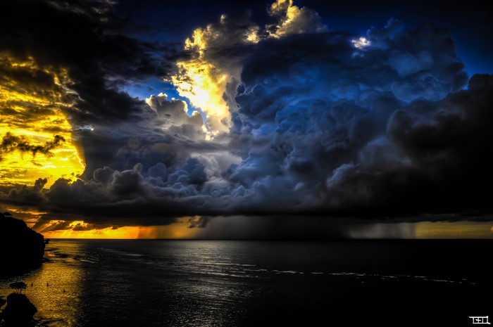 Dramatic storm clouds over the sea at sunset