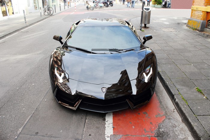 Black Lamborghini Aventador LP700-4 parked on a street