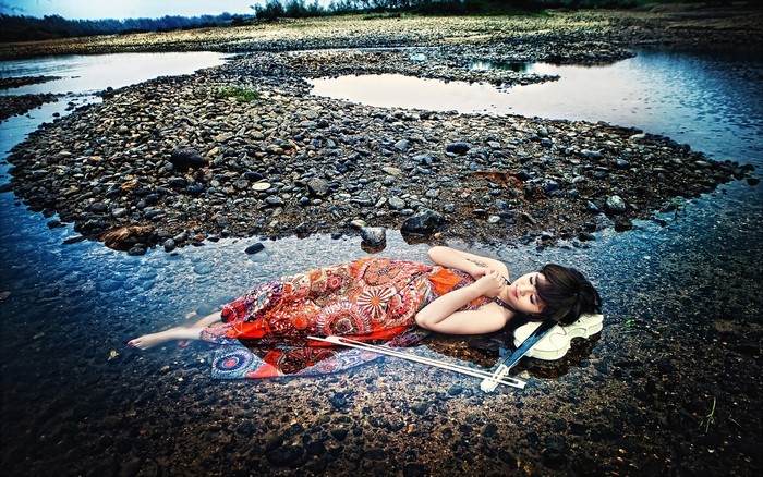 Linh Thuy Dang with a violin lying in stones