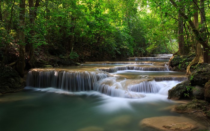 Tiered waterfalls in a lush green forest