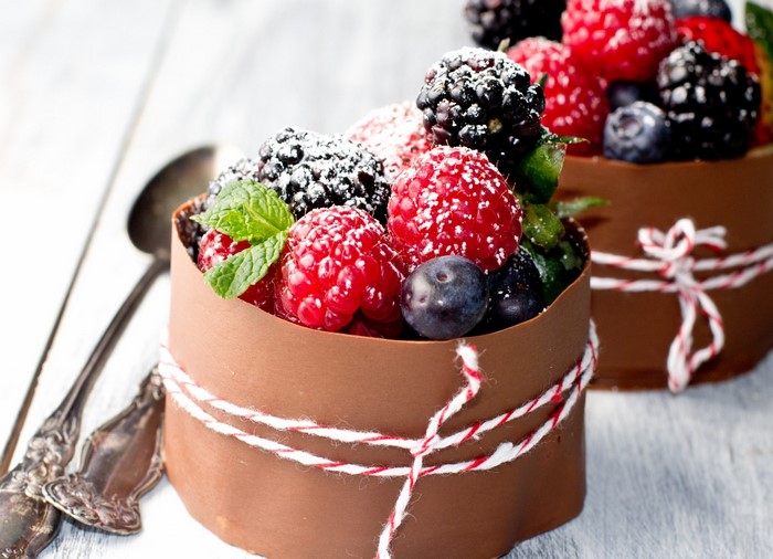Chocolate dessert cups filled with berries and mint