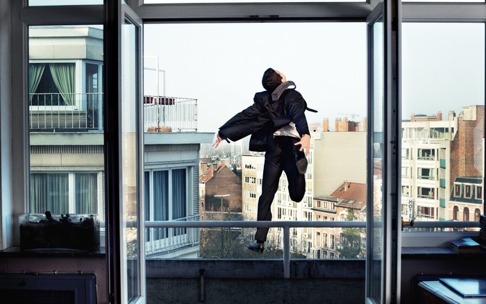 Man in suit jumping from a balcony