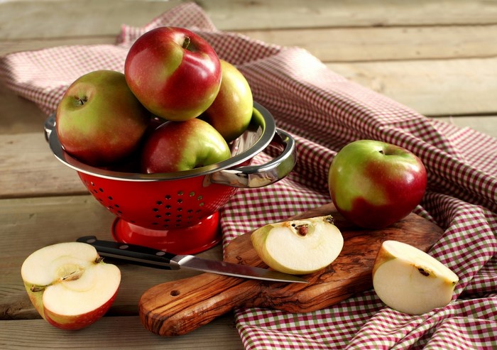Apples in a colander with a knife