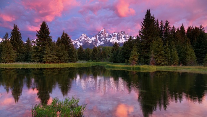 Grand Teton Mountains reflected in a lake at sunset