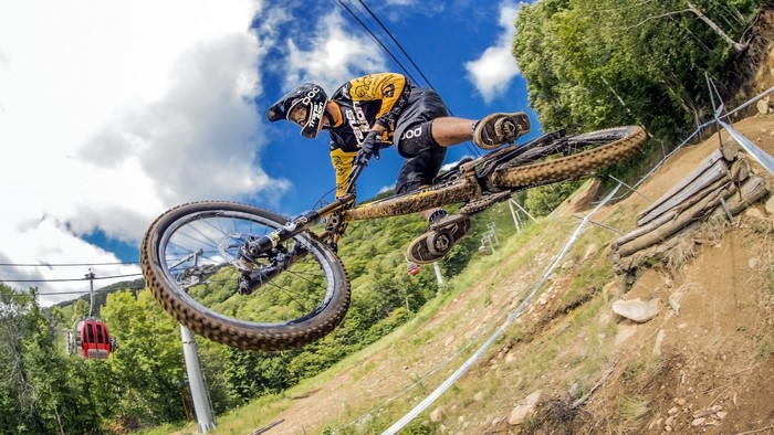 Man on a mountain bike jumping over a dirt track