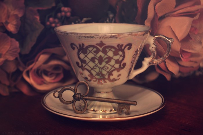 Antique teacup and saucer with a key