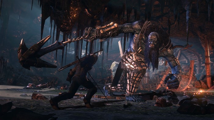 Geralt fighting a monster in a cave