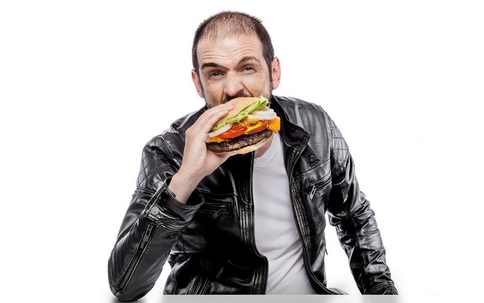 Man in leather jacket eating a hamburger