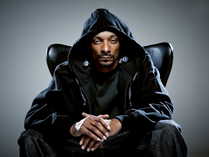 Snoop Dogg sitting in a chair wearing a hoodie