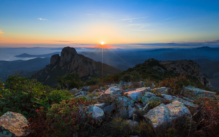 Sunrise over rocky mountains and sea