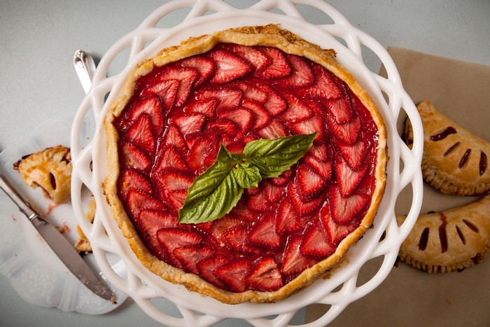Strawberry pie with basil on a white cake stand