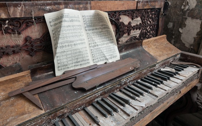 Old abandoned piano with sheet music