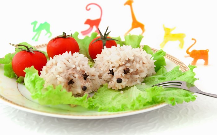Hedgehog rice balls with tomatoes on a plate