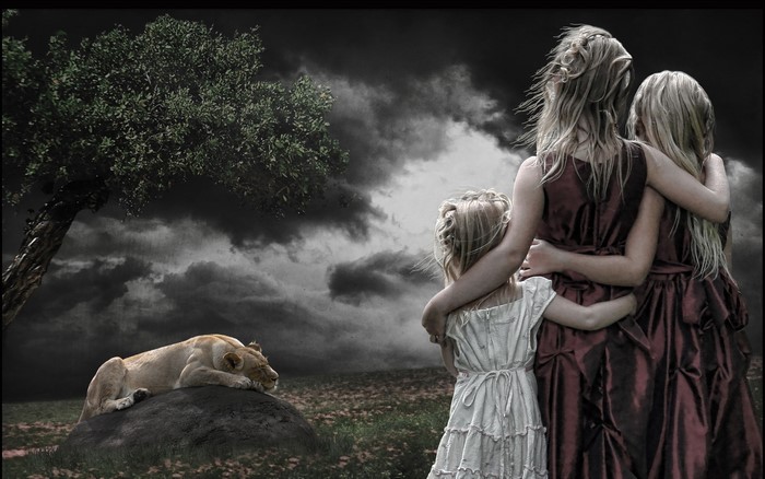 Three girls in dresses and a lioness on a rock
