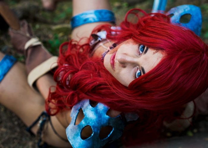 Woman with red hair and blue eyes wearing a blue mask
