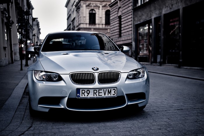 BMW E92 M3 parked on a cobblestone street