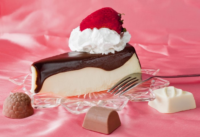 Slice of chocolate cheesecake with strawberry and whipped cream