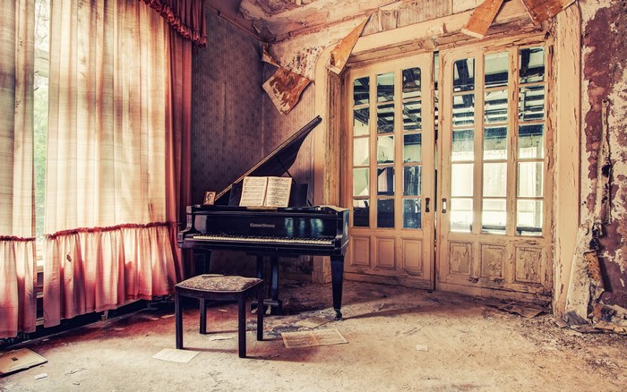 Abandoned room with grand piano and double doors