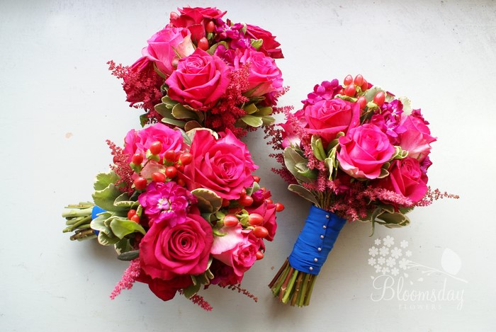 Three pink rose bouquets with red berries