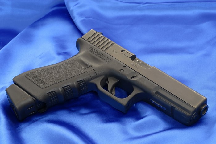 Glock 18C pistol on blue fabric