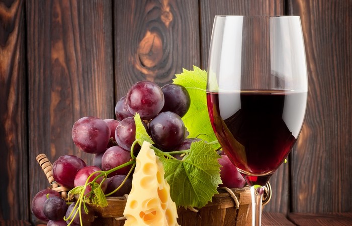 Still-life of red wine, grapes, and cheese