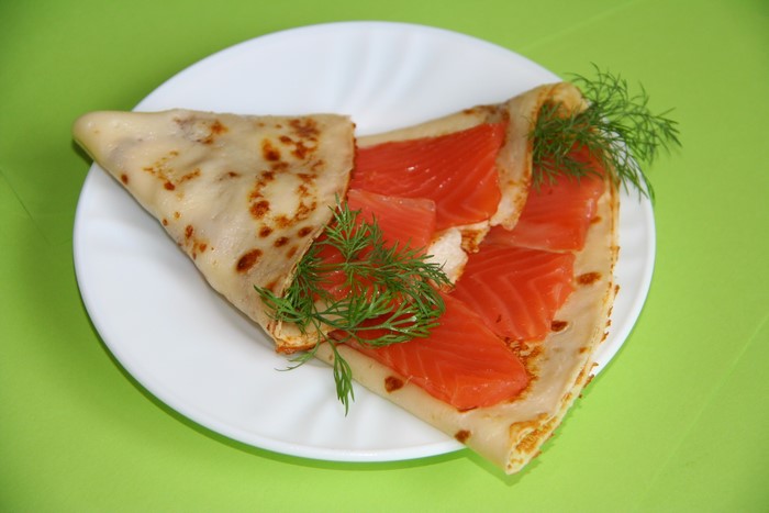 Pancake with smoked salmon and dill on a plate
