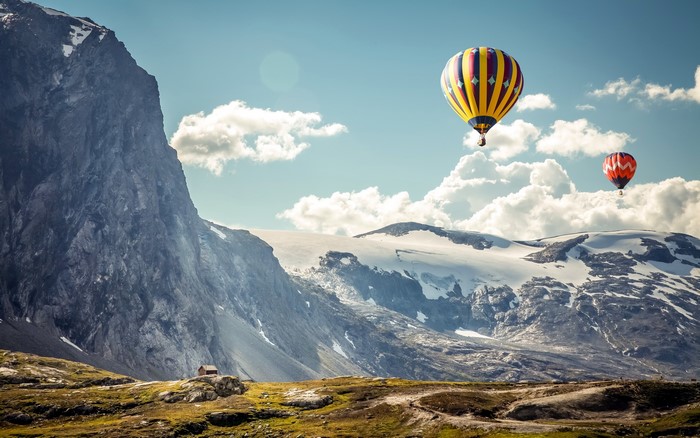 Hot air balloons over snowy mountains