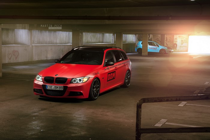 Red BMW 330d wagon in parking garage