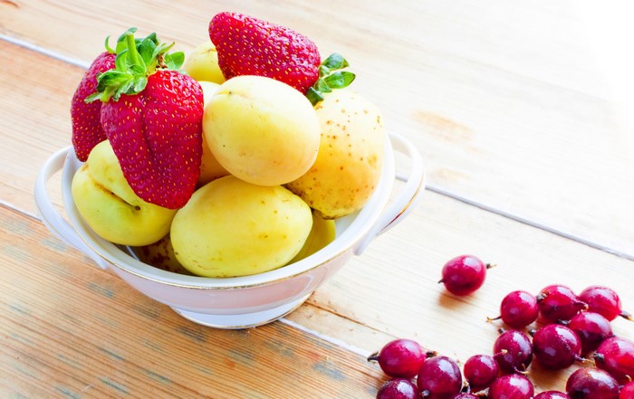 Strawberries and apricots in a bowl with gooseberries