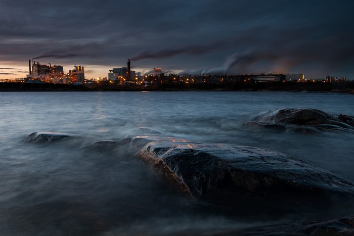 Industrial complex by the water at dusk
