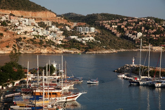 Boats in a harbor with a town on a hillside in Turkey
